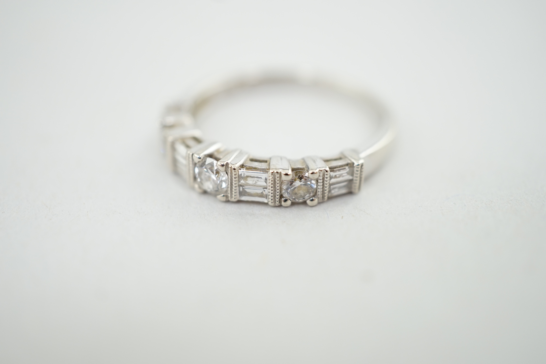 A modern 14k white gold, baguette and round cut diamond set half eternity ring